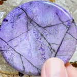 A person holding a sugilite necklace