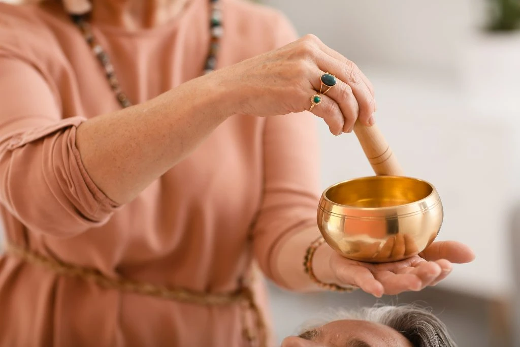 Therapist performing reiki singing bowl ritual