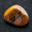 A polished Tiger's Eye crystal on a black background