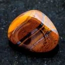 Tiger's eye crystal placed on a black surface table