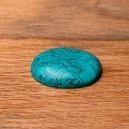 A polished turquoise crystal on the table