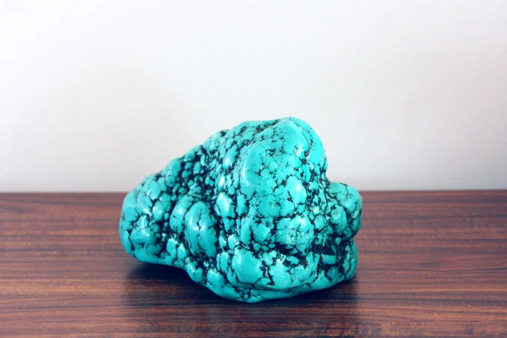 A raw turquoise crystal on the table