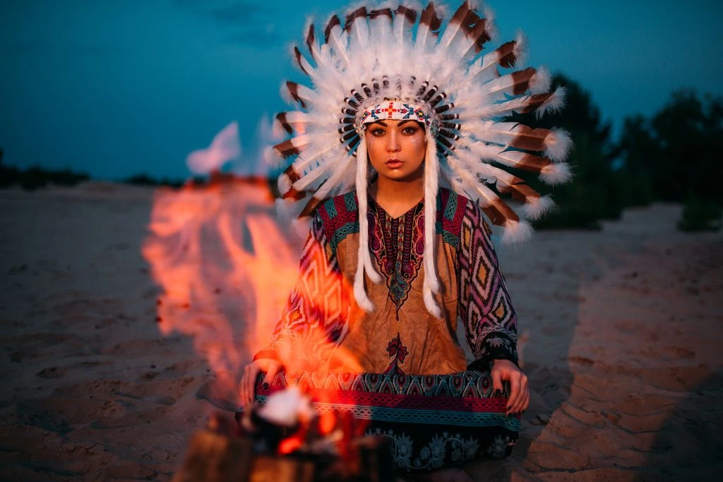american native shaman in front of a bonfire
