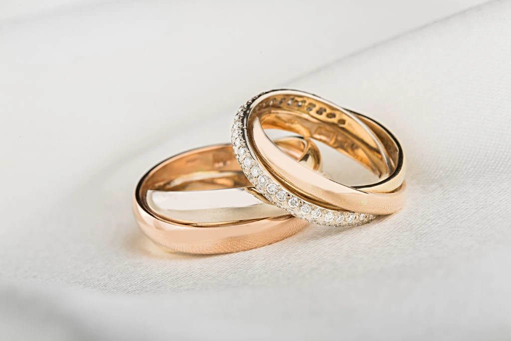 diamond studded gold ring on a grayish textile