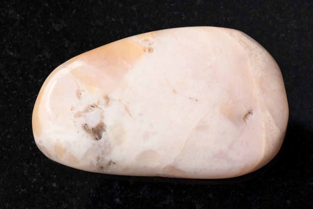 A pink opal on a black background