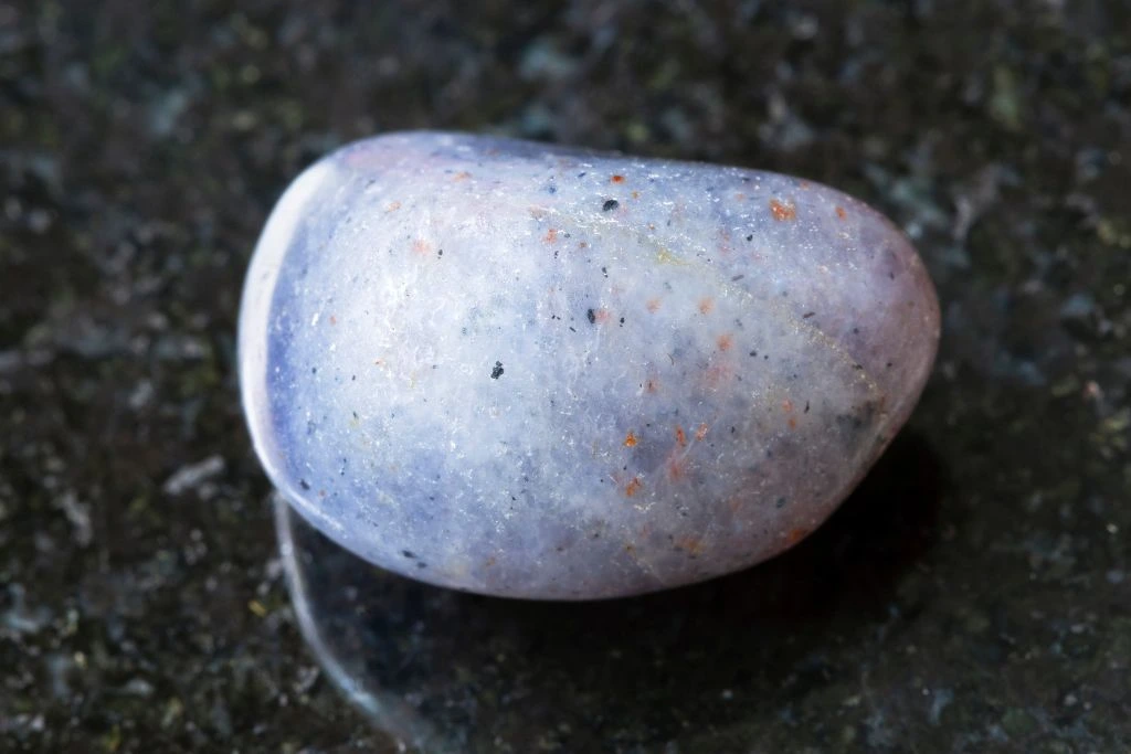 a polished iolite on a black granite