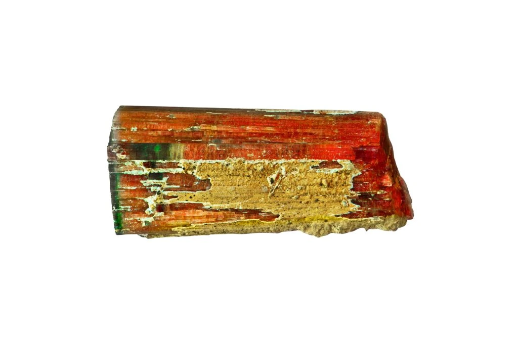 Raw orange tourmaline crystal on a white background