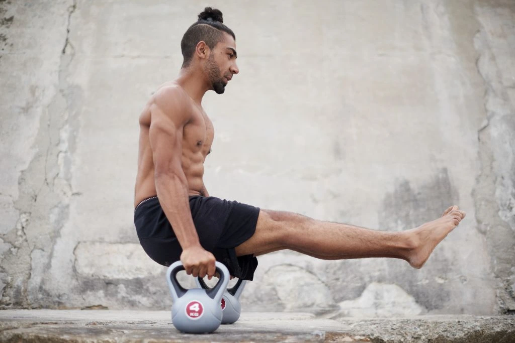 a man balancing in between two kettle bells depicting natural power