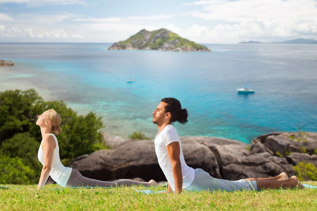 A couple making a yoga cobra pose in nature