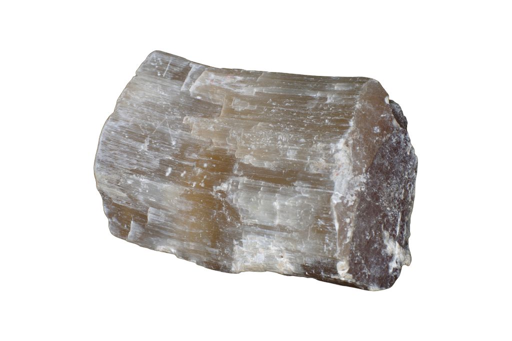 A raw selenite crystal on a white background