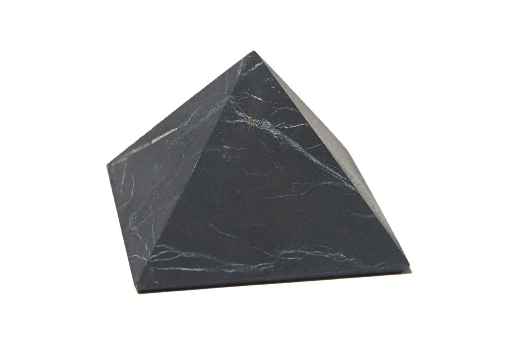 A Shungite crystal pyramid on a white background