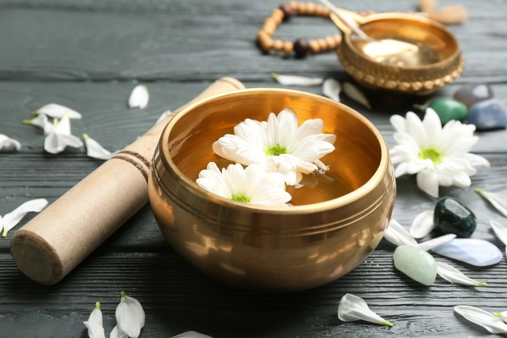 A singing bowl with two white flowers inside