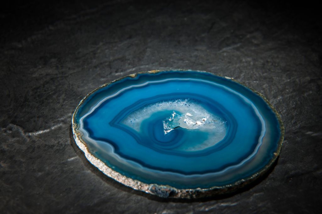 A slice of blue agate crystal on a black granite