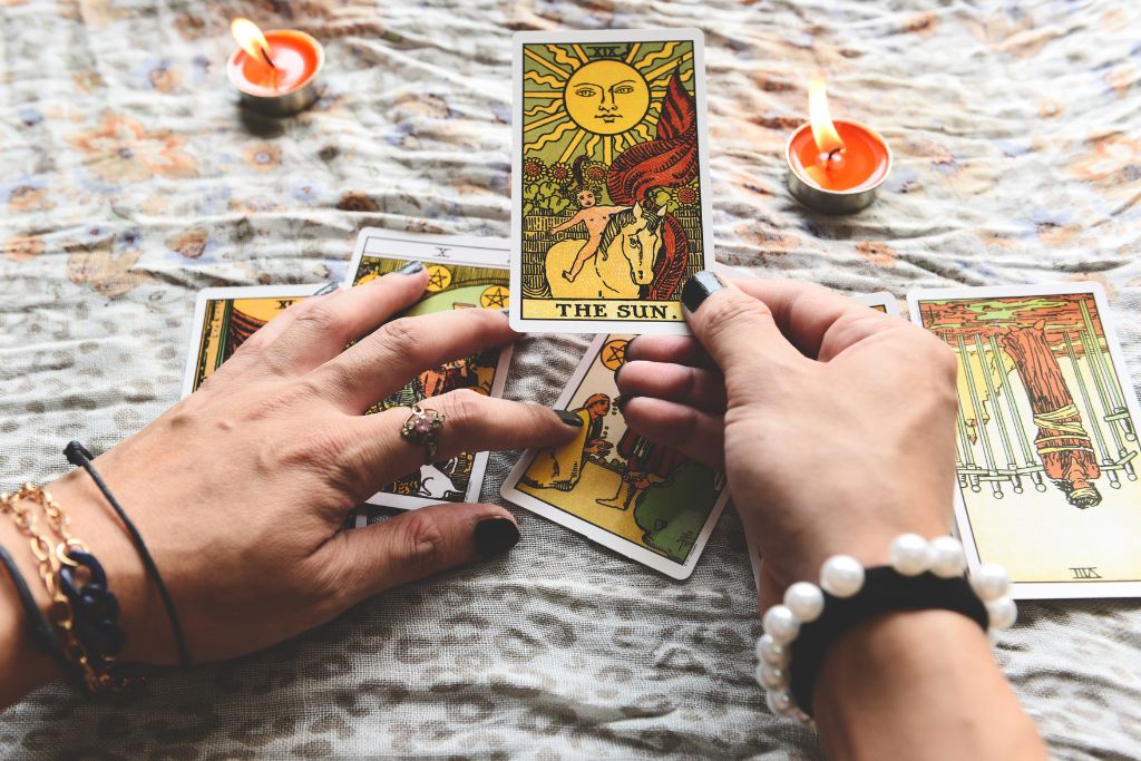 A woman holding a tarot card on the table