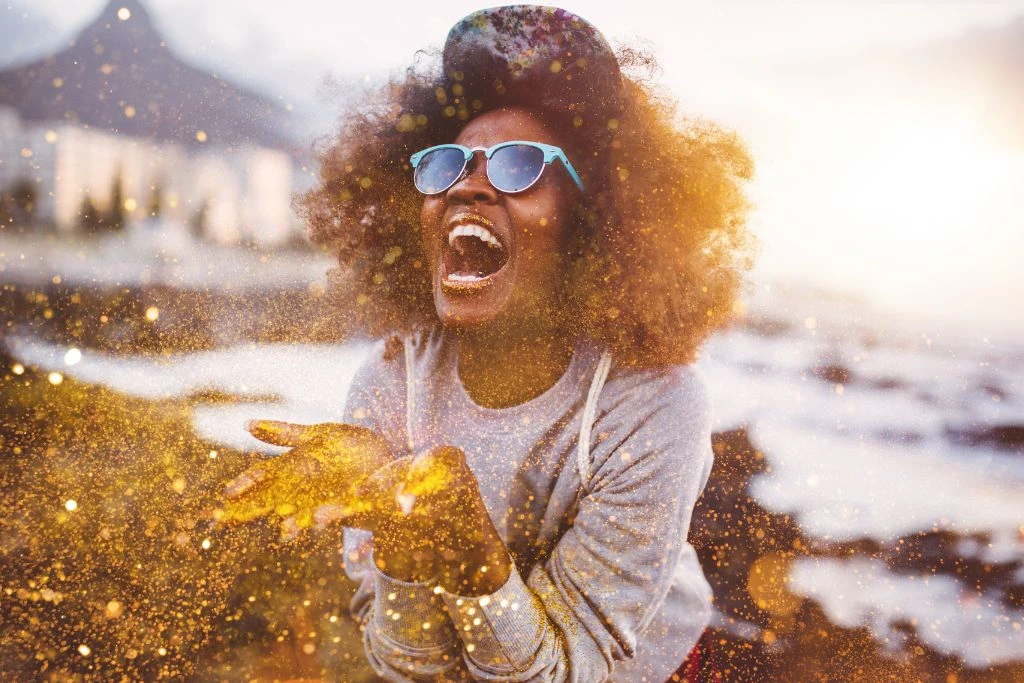 A woman laughing while spreading gold glitter