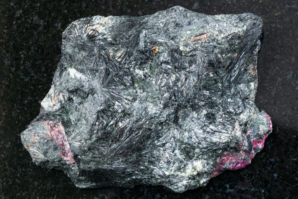 An aegirine crystal on a dark granite