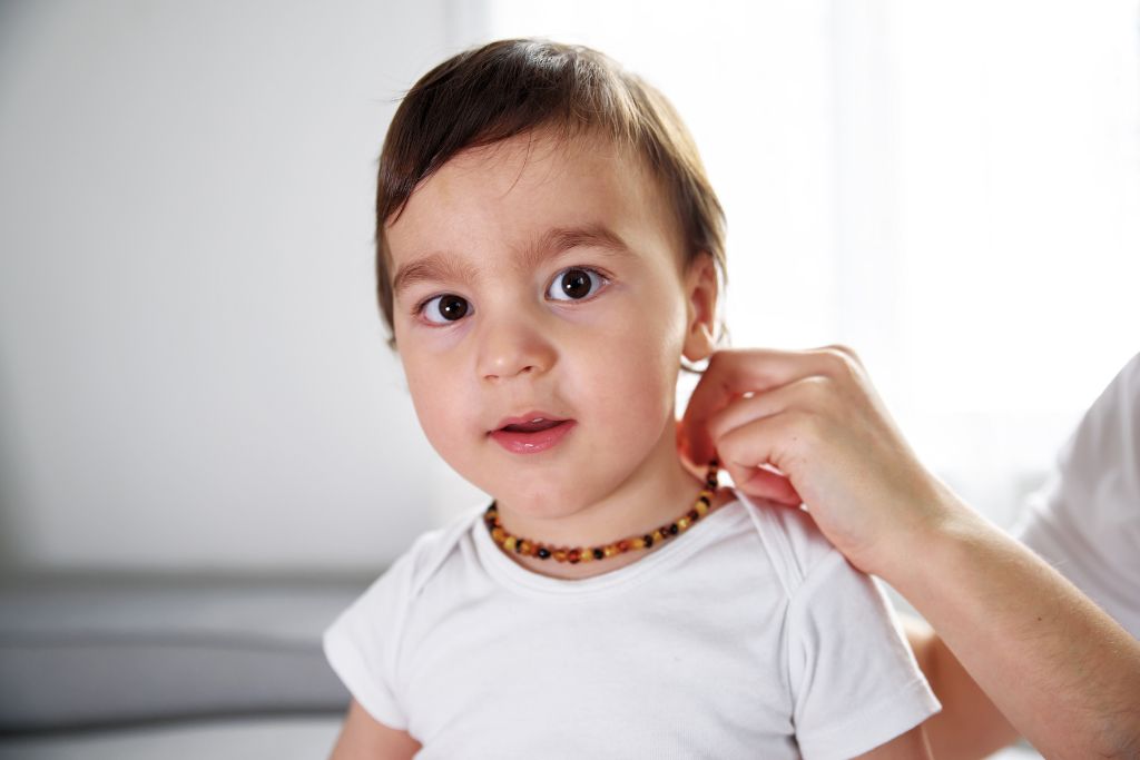 A baby boy wearing a baltic amber necklace