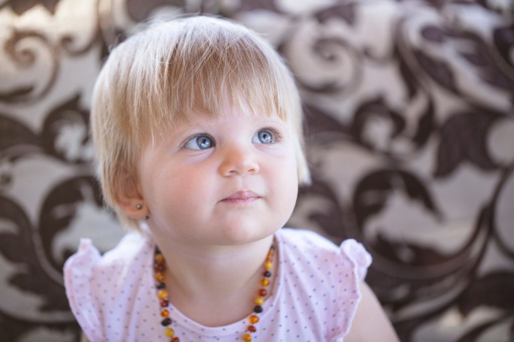 A baby girl wearing a baltic amber necklace