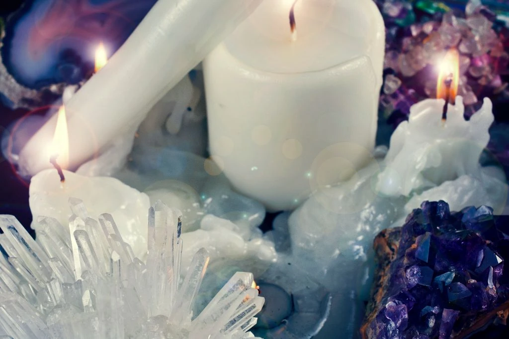 Candles with different kinds of gemstones and crystals