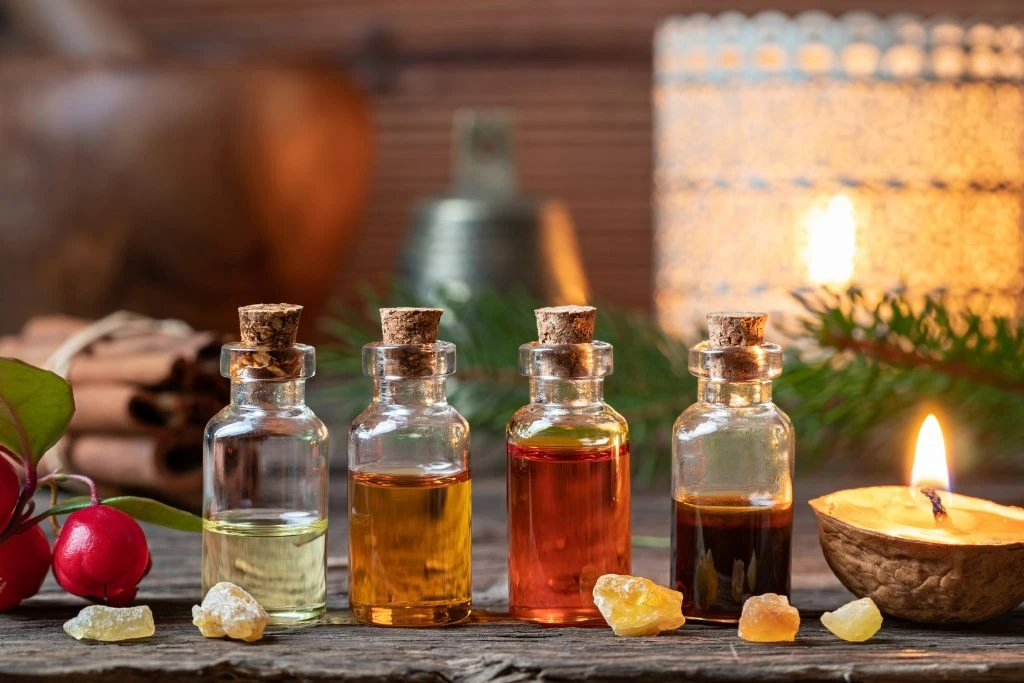 Collection of essential oils beside few crystals and a candle