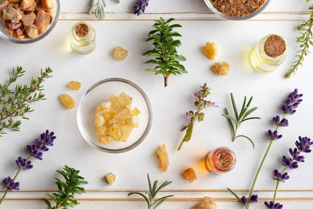 Essential oils, herbs, and a crystals on a dirty white background