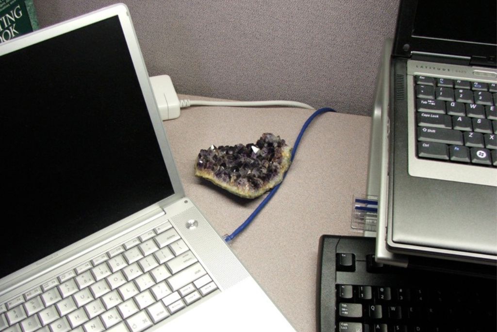 An Amethyst crystal and laptops at a desk work station. Image Source: flickr.com | Kelly Cookson