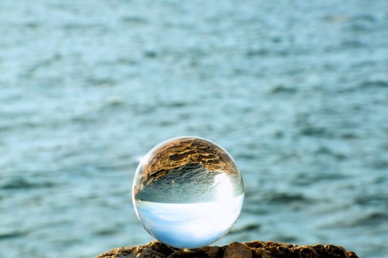 crystal ball placed on an edge of a cliff with a sea on a background