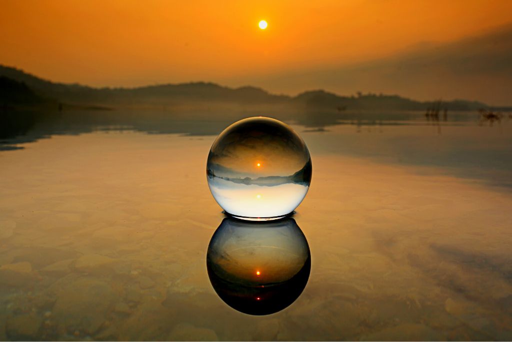 Crystal ball placed on water and have a sunset background