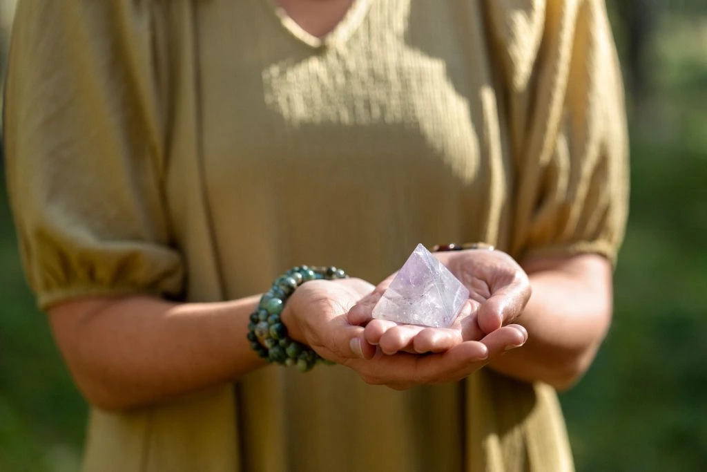 A woman holding a crystal pyramid