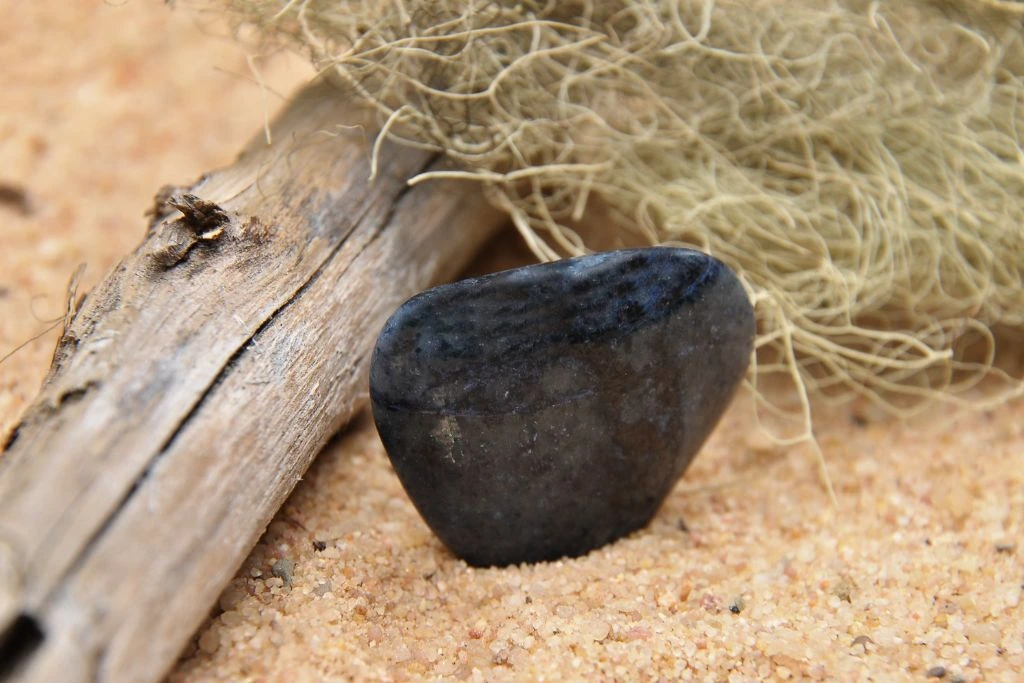 a polished dumortierite crystal on the sand