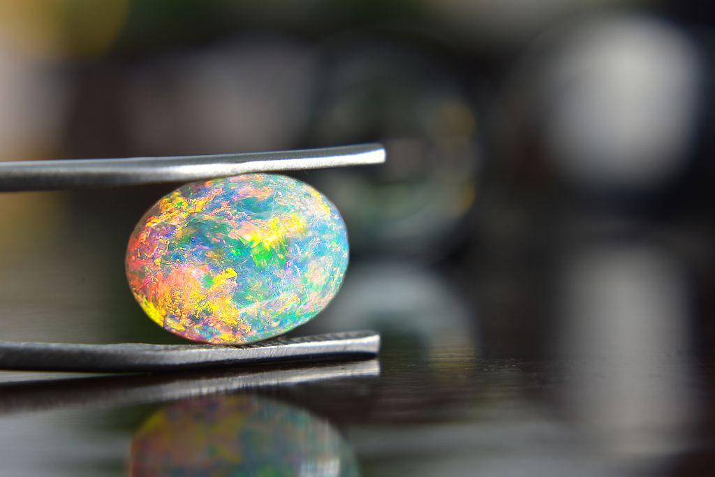 Ethiopian Opal held by tweezer