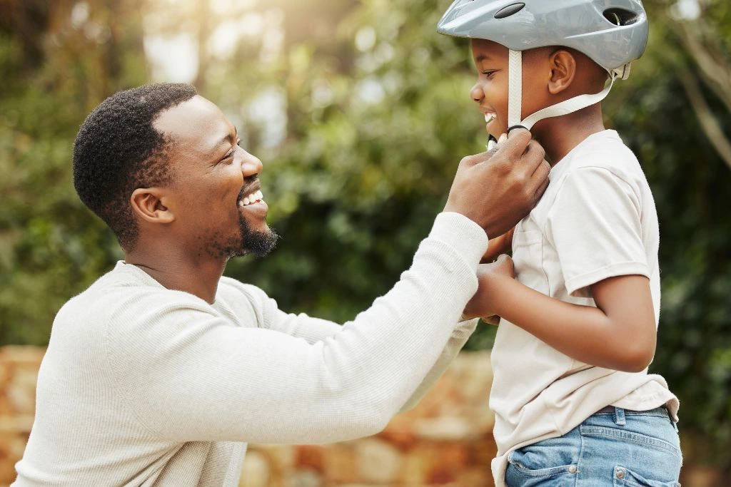 A Father adjusting his son helmet