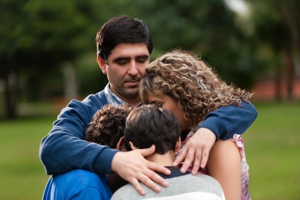 The father hugging his family in nature