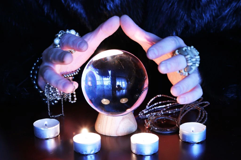 A person hands above the crystal ball