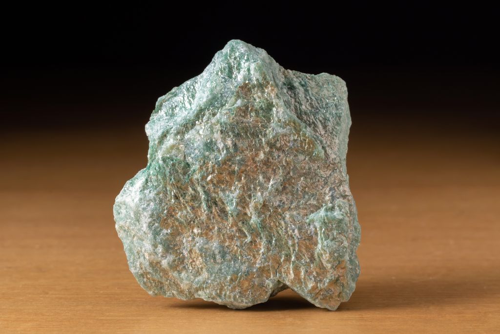 A fuchsite crystal on a wooden table