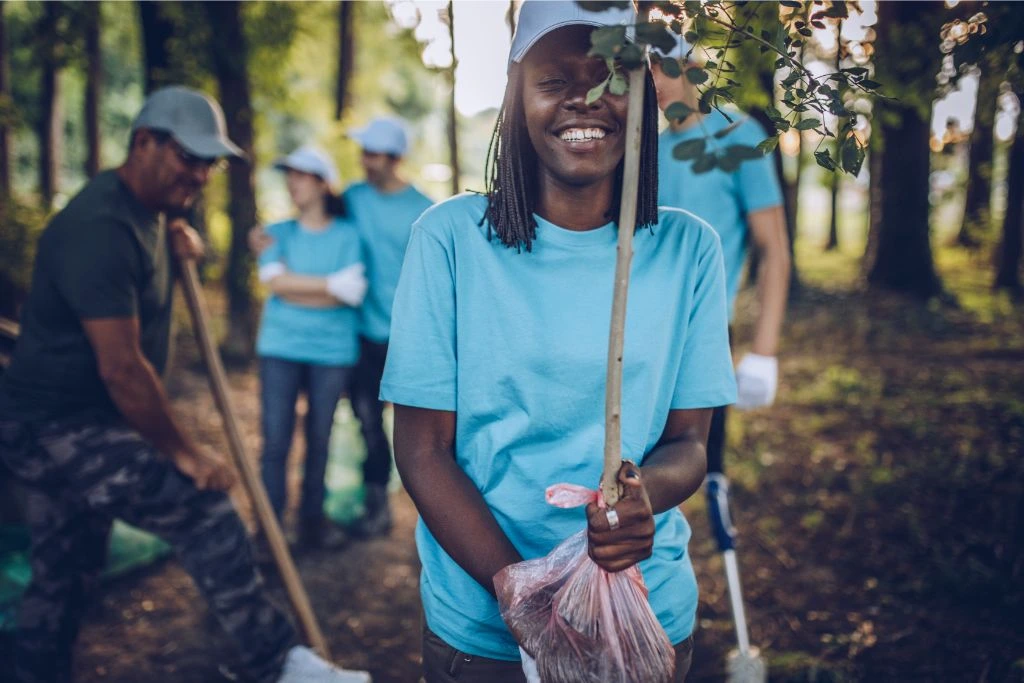 Girl smiling while cleaning in the forest