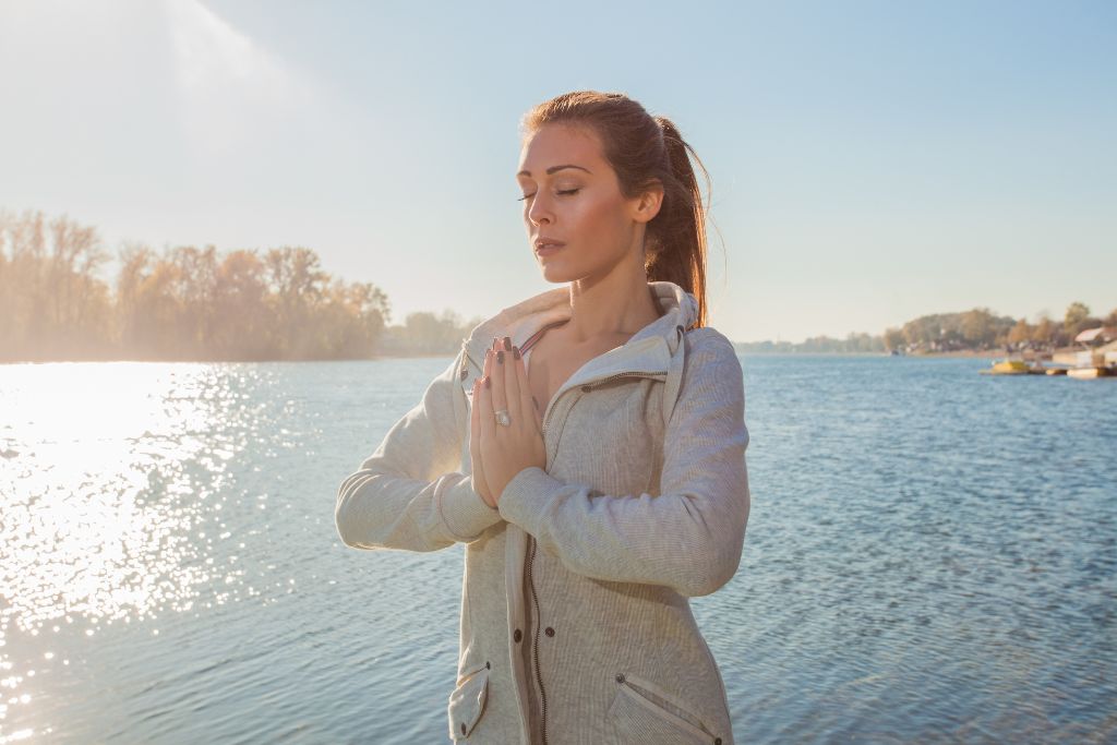 A woman clasping her hands as a sign of her inner peace