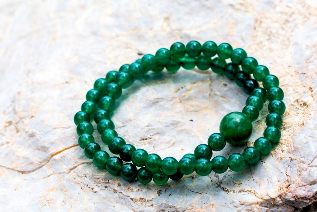 two jade crystal bracelets placed on a gray granite table