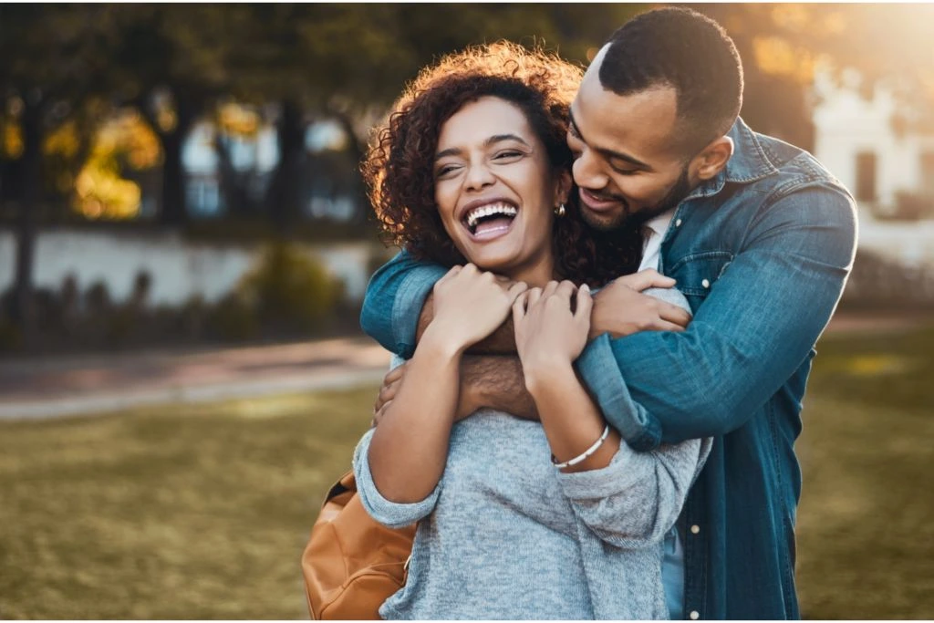 A man embraces a woman in nature