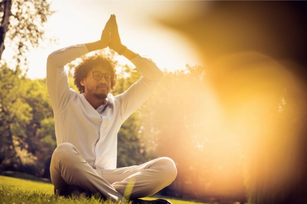 Man with both hands above his head in a praying position 