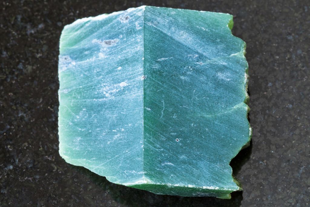 A Nephrite slab on a black granite