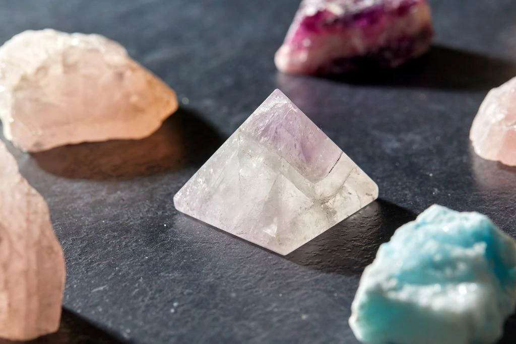 A quartz crystal pyramid and other crystals on a slate