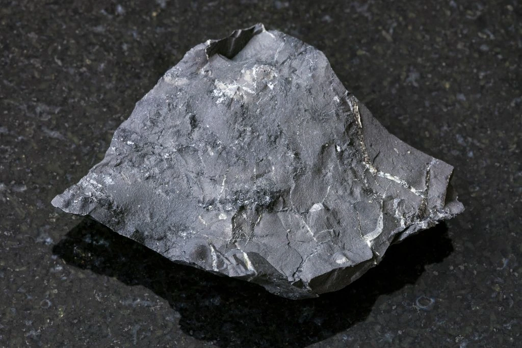 Shungite stone on a black granite