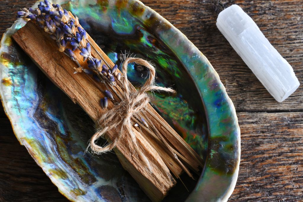 Selenite crystal beside a sage on plate