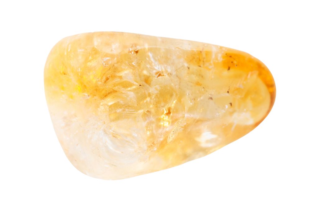 Tumbled citrine gemstone on a white background