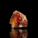 a vanadinite crystal on a dark reflective background