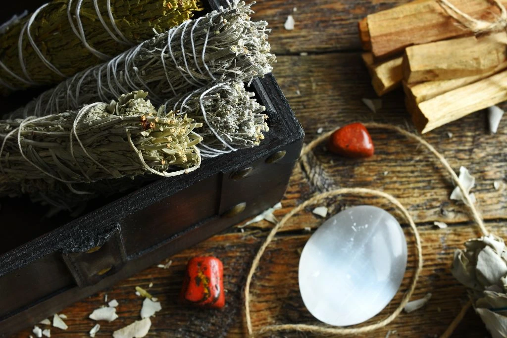 White sage smudge sticks in a box with a selenite crystal on the table