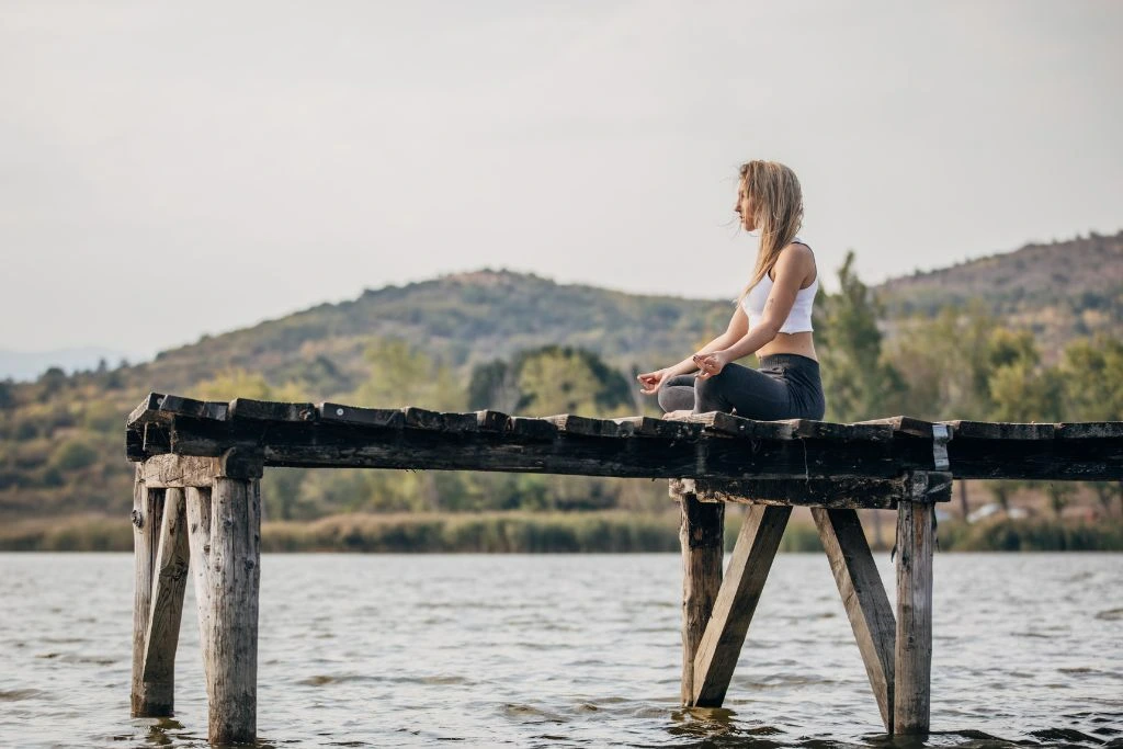 A woman meditating on the dock