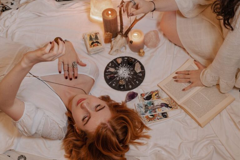 woman practicing crystals programming while surrounded by divination tools