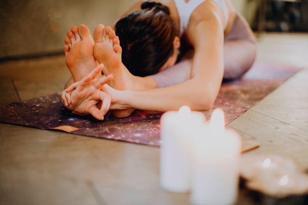 Woman doing yoga peacefully and lighted two candles